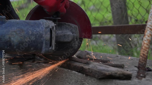 Workers are sawing rebar on concrete with a saw blade on an autumn day