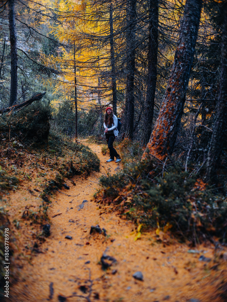 Obraz premium Woman hiking in the Swiss Alps in October with autumn-winter atmosphere, mountains and light snow
