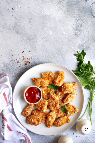 Fresh  homemade crispy chicken nuggets with ketchup on a plate . Top view with copy space.