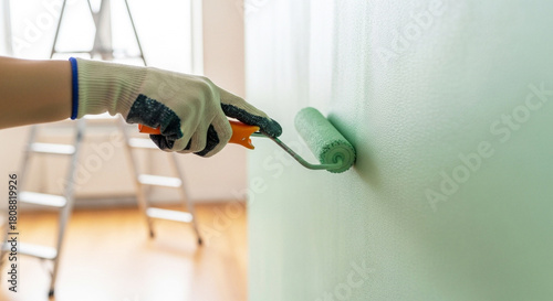 Wallpaper Mural Hand with paint roller painting wall, home renovation and interior design in bright room Torontodigital.ca