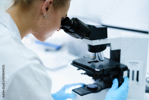 A pharmaceutical Quality Control QC team ensures GxP compliance. Two scientists review an electronic batch record on a tablet while a third performs a required analytical test.