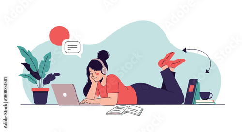A young woman comfortably lies on the floor, using a laptop while wearing headphones, surrounded by books and a plant, illustrating a relaxed work from home lifestyle.