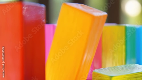 Wallpaper Mural Brightly colored wooden blocks are meticulously lined up on a warm wooden table, illuminated by sunlight in a cheerful afternoon setting, creating a playful atmosphere. Torontodigital.ca