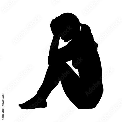 Black silhouette of a sad girl sitting on the floor with knees drawn up and face covered by hands. Emotional scene without background.