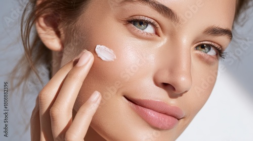 A close-up of a young woman applying skincare cream, showcasing healthy, glowing skin, This image can be used in beauty, skincare, or wellness marketing materials,
