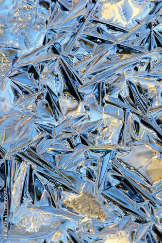 Details of ice, reflecting afternoon colors in the forest at pond called Pikku Katavalammi at Tammela, Finland. 