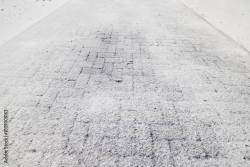 Winter texture of paving slabs covered with snow, top view, background surface in snow