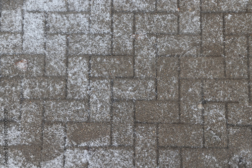 Winter texture of paving slabs covered with snow, top view, background surface in snow