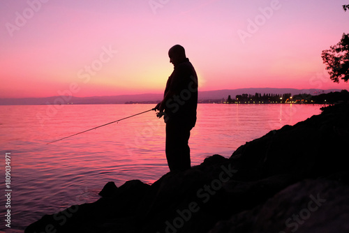 Silhouette d'un homme qui pêche à la ligne sur les berges du lac Léman, Lausanne, Suisse