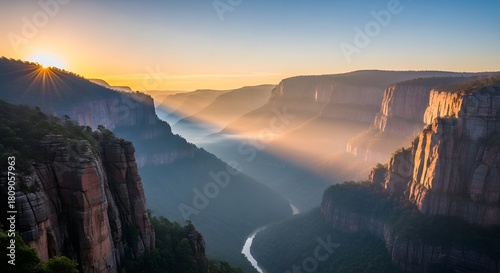 A scenic view of a canyon with a river flowing through it during a bright and colorful sunrise