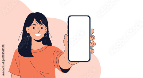 Cheerful young woman with dark hair and hoop earrings holding up a smartphone with a blank screen for a mockup presentation.
