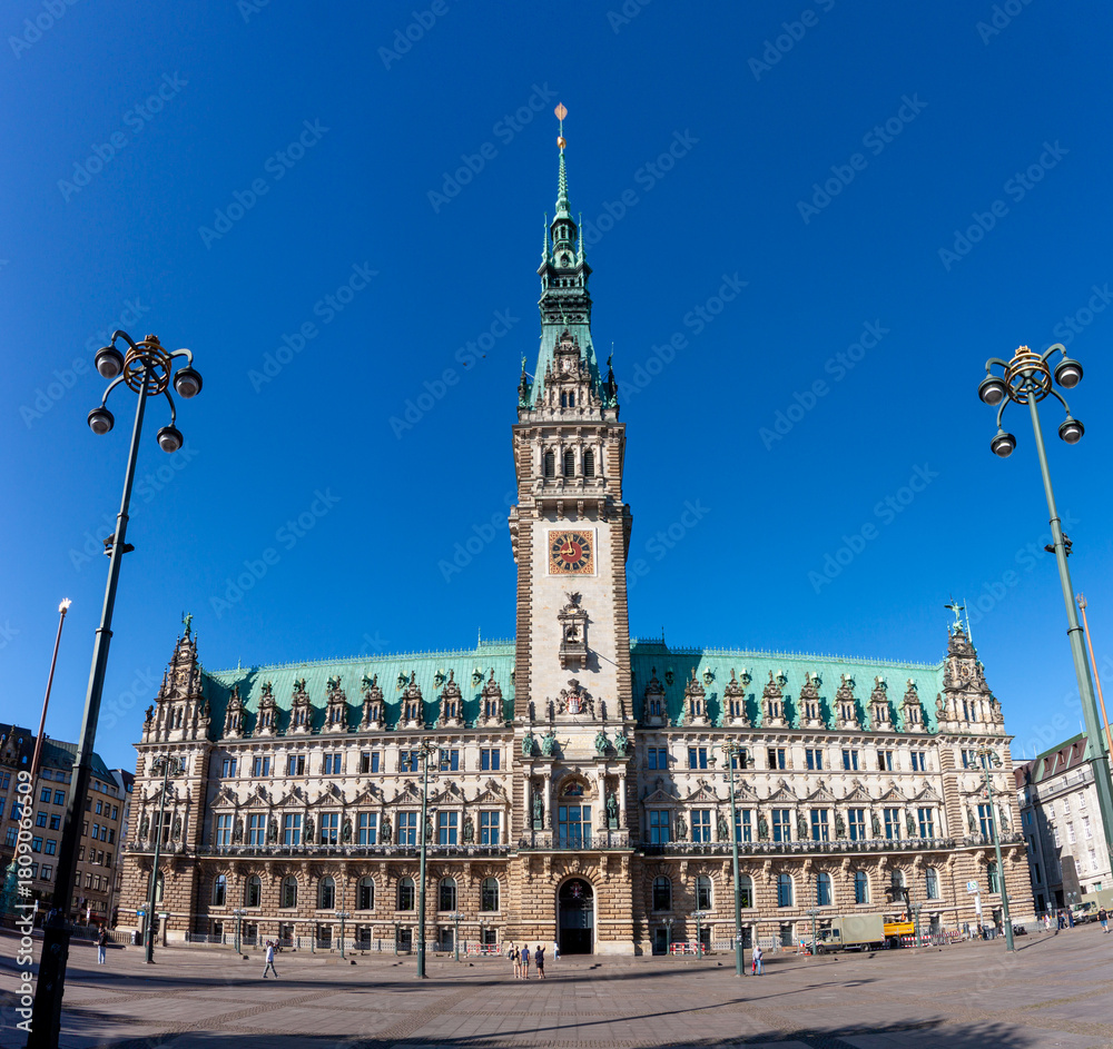 Obraz premium Hamburg City Hall in Germany, a grand Neo-Renaissance building with its prominent tower and intricate facade under a clear blue sky