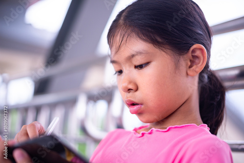 Focused Young Girl Using Digital Tablet with Stylus in Modern