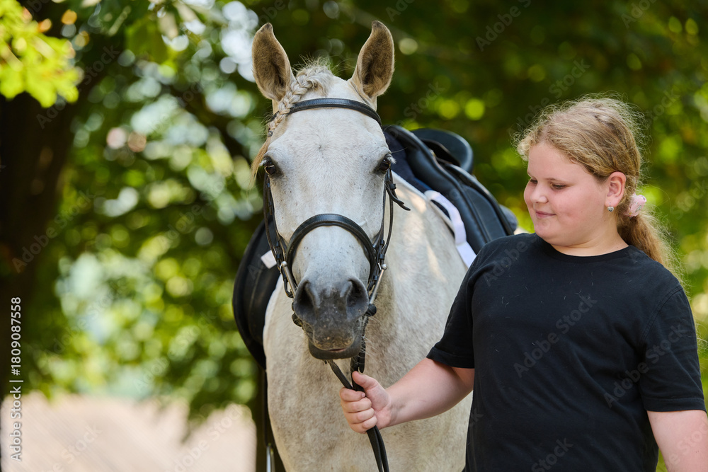Fototapeta premium Girl with her beautiful white horse in nature, equestrian lifestyle, friendship and love, horse riding, outdoor activity, summer day, animal care, happy childhood.