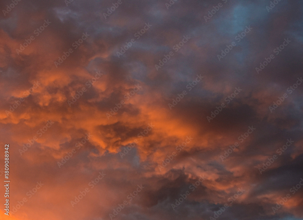Fototapeta premium Luminous sunset sky casting vibrant hues across gentle and heavy clouds
