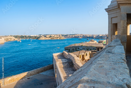 Blurred wall and bastion at Fort St Elmo, view point to blue sea and historical buildings, Valletta MALTA