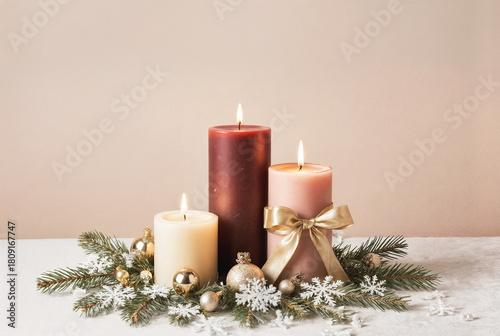 Festive Christmas composition with three burning candles fir branches and gold decorations on beige background