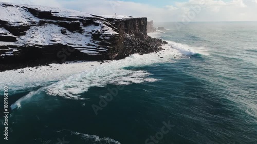 Wallpaper Mural Aerial view of waves breaking on the snowy cliffs along the coast storm ocean sea on sunrise in winter Torontodigital.ca