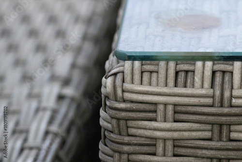 Close-up of synthetic rattan garden furniture texture with glass table corner
