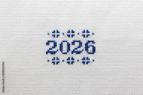2026 is embroidered with blue thread on white fabric. 