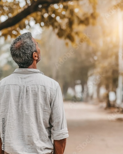 Man gazing upward in a serene, natural outdoor setting.