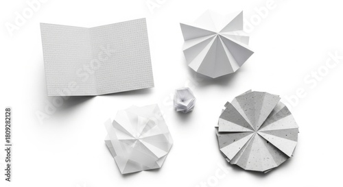 Minimalist White Paper Umbrellas with Notebook and Geometric Paper Crafts on White Background