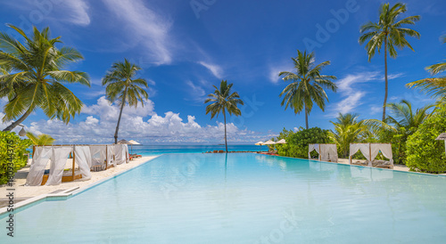 Luxury outdoors resort infinity pool view. Fantastic summer holiday destination relax sun beds umbrellas, palm trees. Tranquil poolside sea sky vacation escape. Perfect tropical travel landscape coast