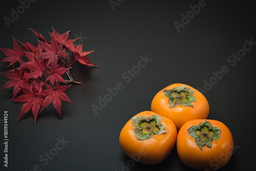 美しく紅葉したもみじの葉と秋の代表的な果物の柿
