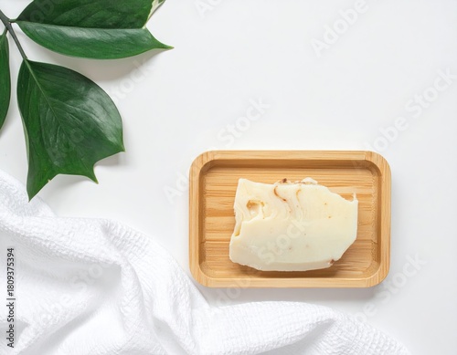 Soap on wood with greenery & towel, clean white backdrop