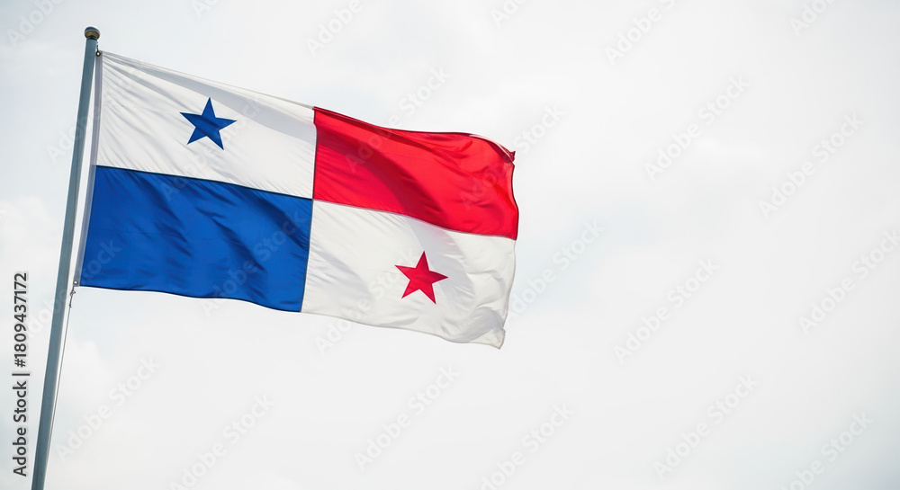 Naklejka premium Celebrating Panama Independence Day with Panamanian flag waving gently in breeze against cloudy sky. Panama Independence Day symbolizes patriotism and cultural identity.