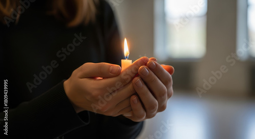 Holding candle during Suicide Loss Day, woman gently holds burning candle in remembrance. Suicide Loss Day serves as time for reflection and remembrance.