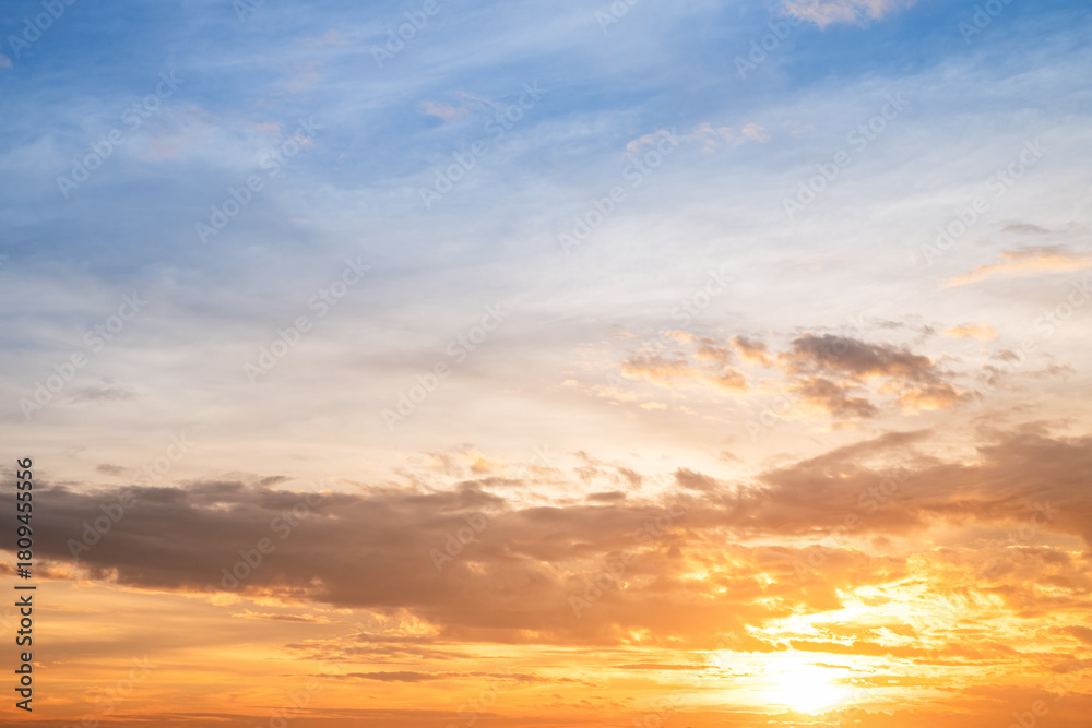 Obraz premium Sunset or sunrise sky with a vibrant gradient of orange, gold, and soft blue. Clear atmosphere with wispy clouds. Peaceful, natural light background. hope, freedom, new day and inspirational Concepts