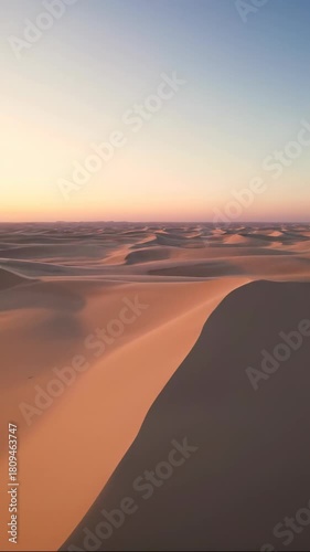 Breathtaking sweeping aerial view over an expansive blank desert landscape where atmospheric light creates a subtle natural color spectrum gradient blank, texture, drone
