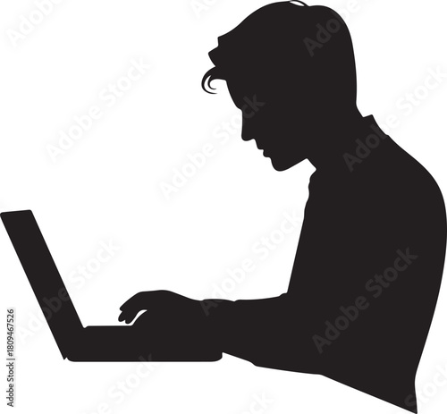 Silhouette of a young man working on a laptop computer
