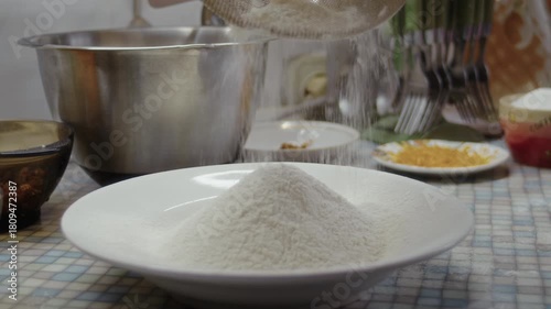 Close-up, the process of sifting flour through a sieve on a kitchen baking table