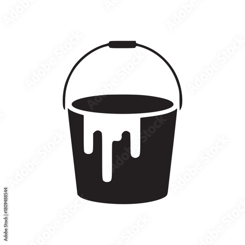 A black paint bucket with white paint dripping down the side isolated on a white background view