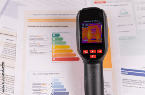 Gros plan sur une caméra thermique avec le dossier de diagnostic DPE d'un appartement pour détecter les fuites de chaleur.