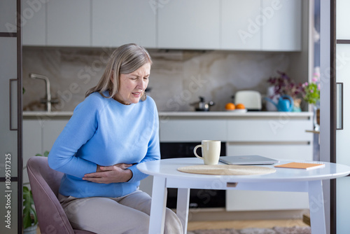 Photography Senior woman suffering from severe stomach pain and discomfort, holding her hand