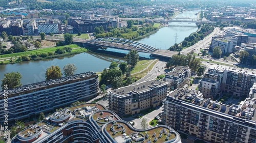 Aerial drone view of modern Wisla Terraces residential buildings in Krakow, Poland, featuring contemporary architecture and unique green roofs near the Vistula River.