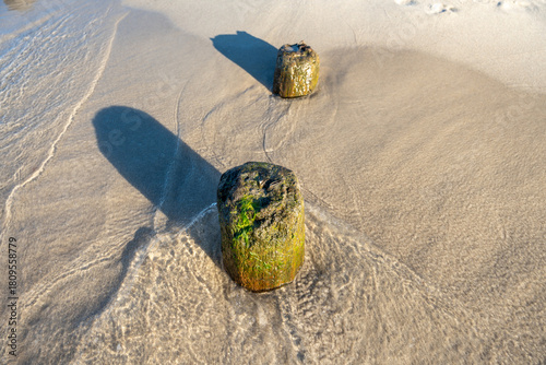 Fototapeta Naklejka Na Ścianę i Meble -  Natural Baltic Sea seascape with weathered structures smooth sand and bright water shaping a peaceful coast