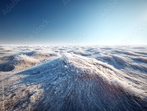 An aerial view of a vast frozen desert with thick snow and ice covering undulating dunes, showing soft light and shadows under a clear gradient blue sky, creating a serene polar-like scene.