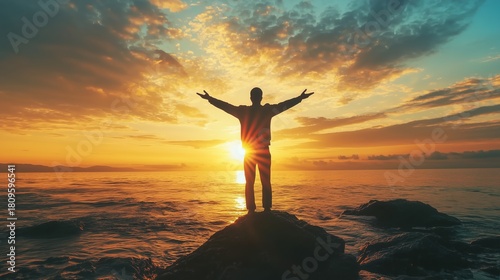 Person on rock, arms wide, facing sunrise over ocean, symbolizing financial freedom and limitless possibilities.