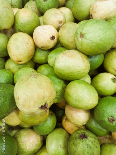A pile of guavas stacked on a supermarket shelf