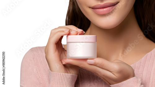 A woman holding a cosmetic jar and smiling  long title A young smiling woman holding a jar of cosmetic or skincare product against a
