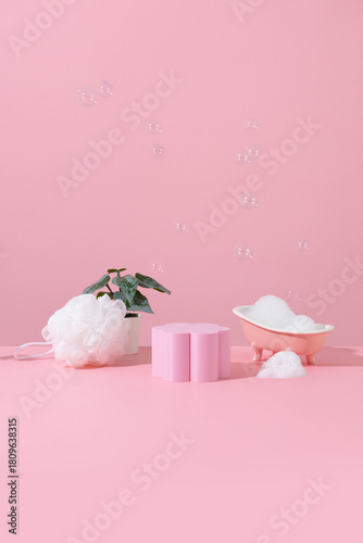 Pink miniature bathtub in pink bathroom with bubble product stand for packshot
