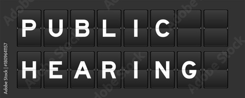 Black color analog flip board with word public hearing on gray background