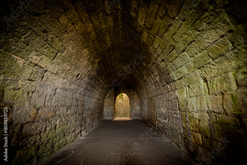 Ancient castle underground cellar of warkworth castle,, Northumberland. UK. Stone walls and cold, damp floor.
