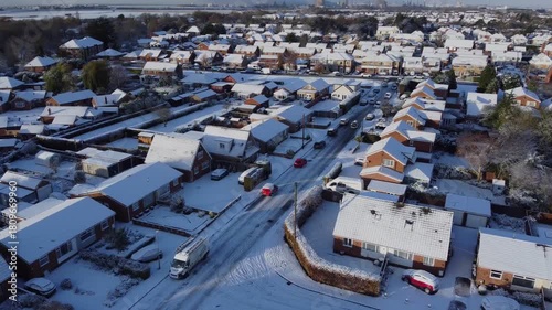 Drone. Road traffic, UK houses covered in snow. Icy winter, Christmas season.