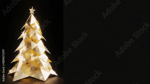 Gold geometric Christmas tree against a stark black background. A star adorns the top