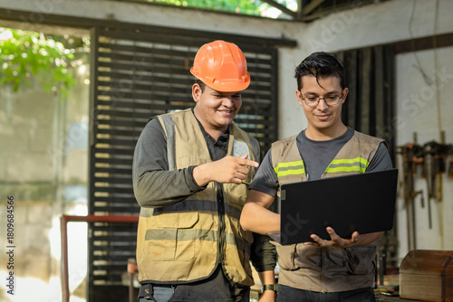 Φωτογραφία Carpentry foreman showing computer to colleague in the workshop